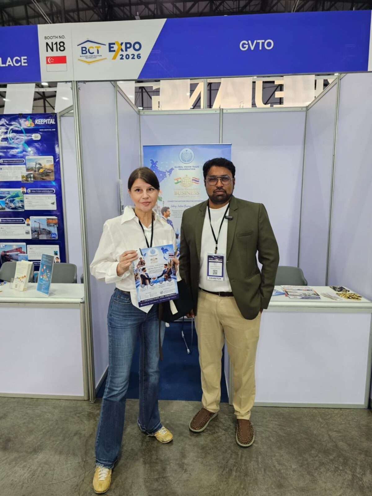 Sharing India–Thailand Opportunities — A visitor holds the India–Thailand Business Conclave 2026 flyer beside a GVTO representative, discussing opportunities between the two markets.